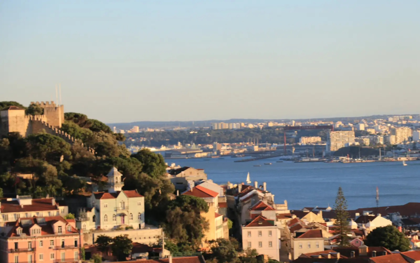 Red roofs of Alfama below the castle with the Tagus estuary behind